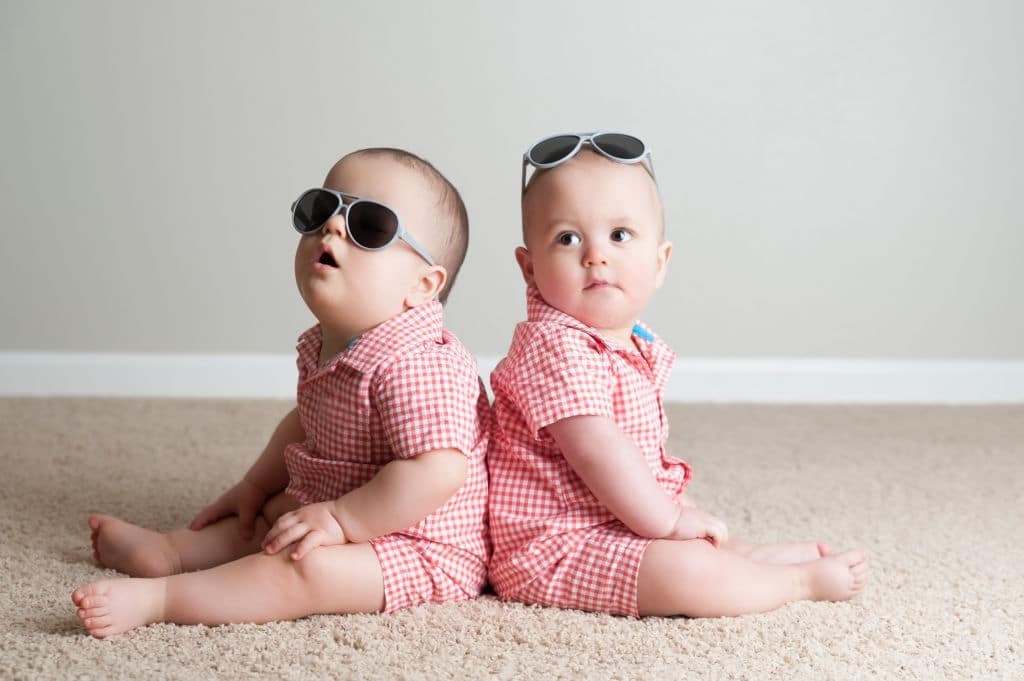 Fraternal twin boys cheerfully play with each other buscar gemelos