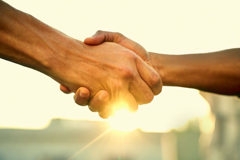 Cropped shot of two people shaking hands outdoors La subrogación es legal en Colombia
