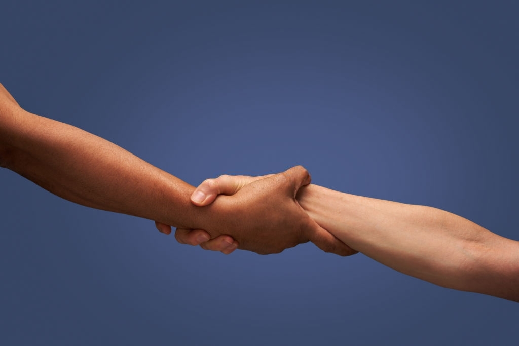 Close up of man and woman holding hands in studio with blue background Como seleccionar una agencia de subrogacion2