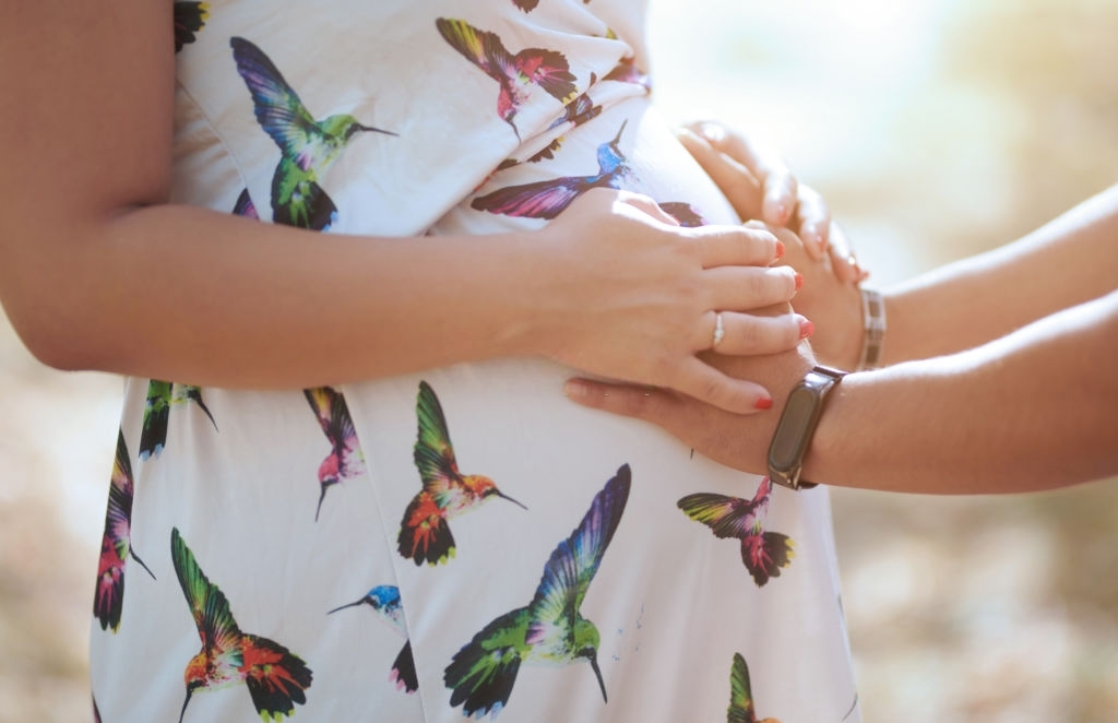 Husband touching pregnant wife's belly. Expecting parents. Quiero convertirme en gestante subrogada