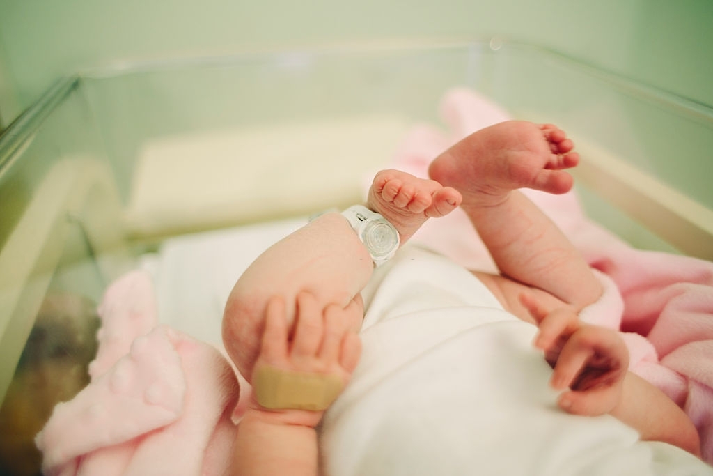 View of baby's feet with a hospital security tag on Padres intencionales en Navidad