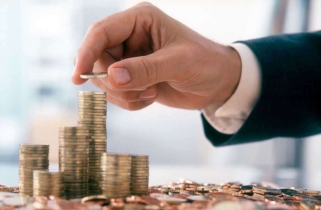 Hand of a mid adult man, wearing a siut, is stacking Euro coins. (2XL-File) Que es el examen genetico preimplantacional o PGD4